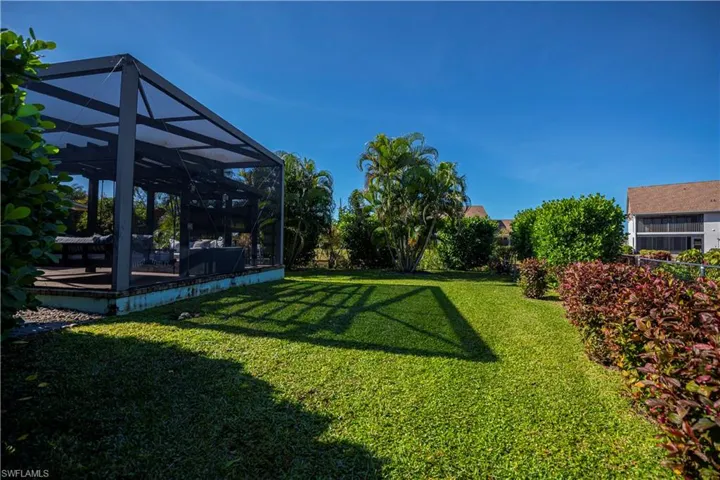Beautiful lush side of home looking at the pergola and swing and gas firepit