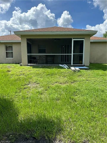 Back of house with a lawn and a patio area