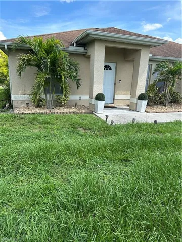 View of exterior entry featuring a yard