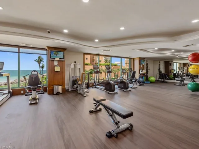 Exercise room with floor to ceiling windows, recessed lighting, and wood finished floors