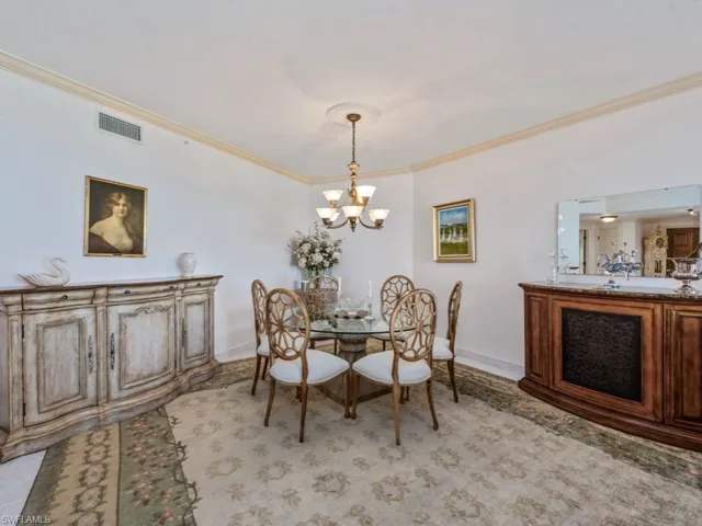 Dining area featuring crown molding and a chandelier