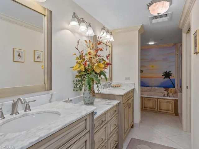 Bathroom with vanity, tile patterned floors, a garden tub, and crown molding
