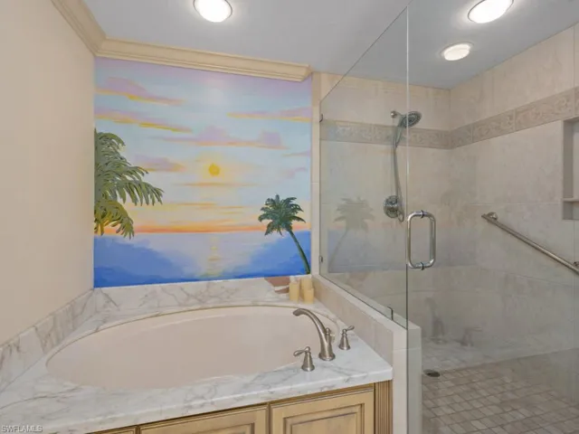 Bathroom with a garden tub, a stall shower, and crown molding
