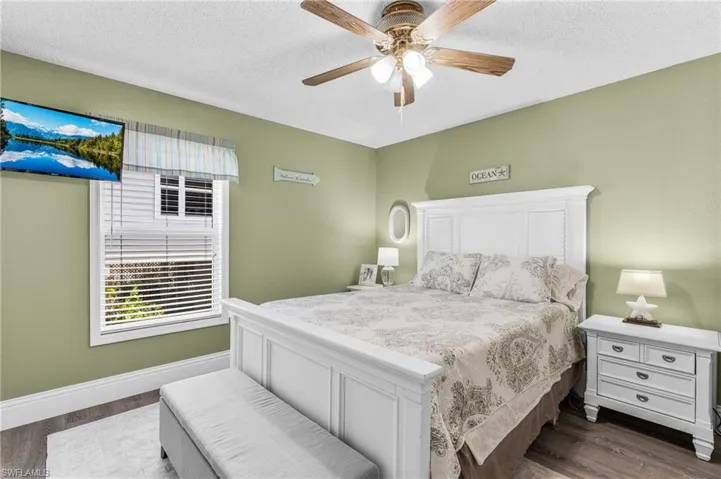 Bedroom featuring a textured ceiling, dark wood-type flooring, and a ceiling fan