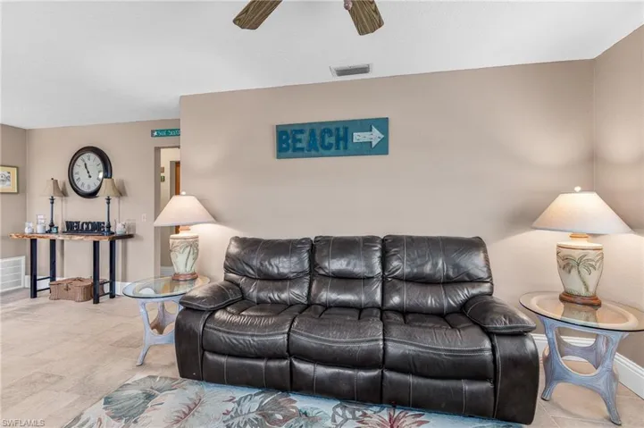 Living area with ceiling fan and tile patterned flooring