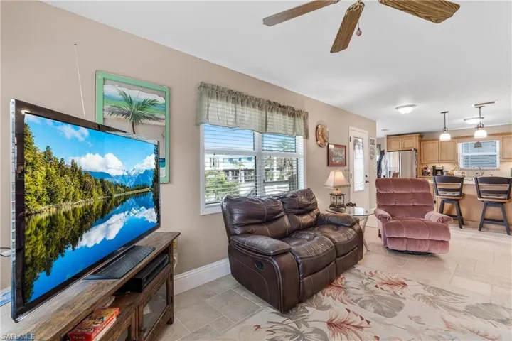 Living room featuring stone tile floors and ceiling fan