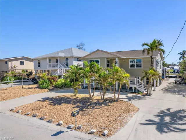 Coastal home with stairs and concrete driveway
