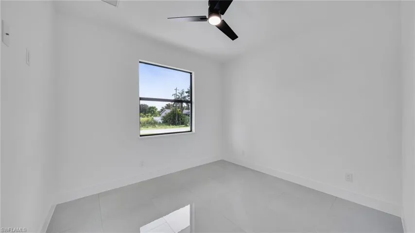 Spare room with a ceiling fan and baseboards