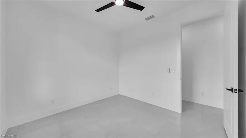 Spare room featuring a ceiling fan and baseboards