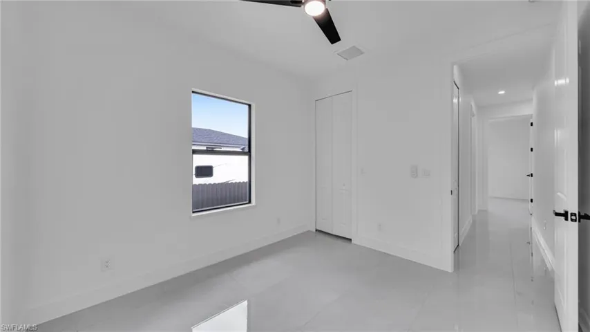 Unfurnished room featuring ceiling fan and baseboards