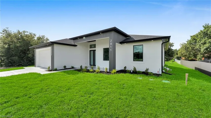 View of front of home featuring an attached garage, driveway, roof with shingles, and stucco siding
