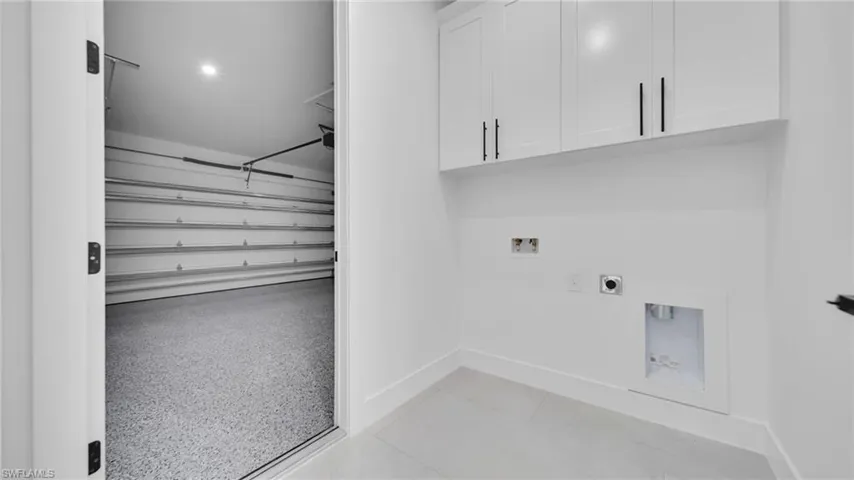 Washroom featuring hookup for a washing machine, cabinet space, and hookup for an electric dryer