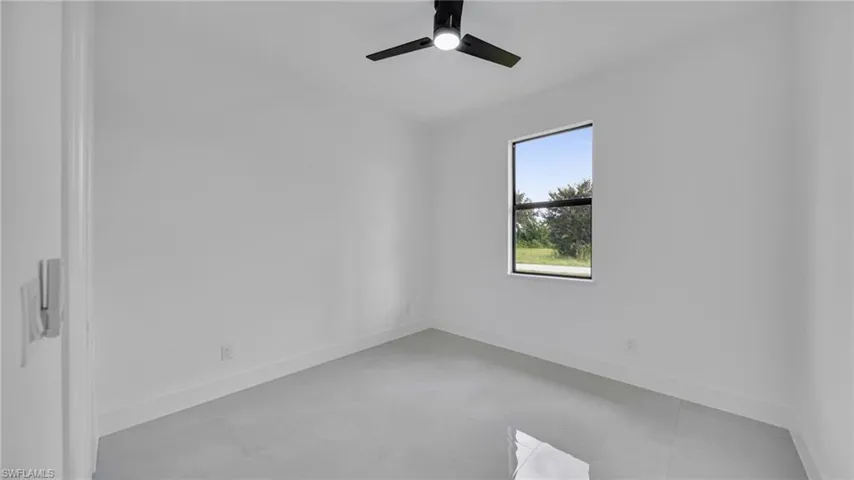 Empty room featuring baseboards and a ceiling fan