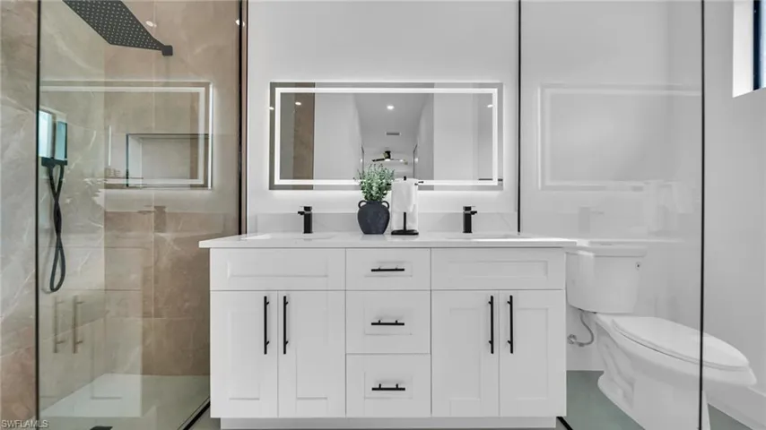 Bathroom featuring a stall shower and double vanity