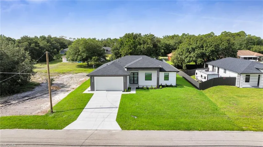 View of front of home with concrete driveway, an attached garage, roof with shingles, and stucco siding