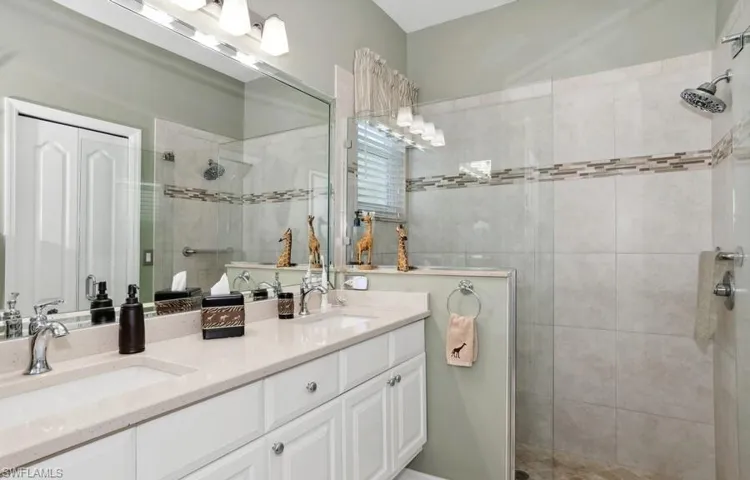 Refurbished Bathroom featuring two sink vanity, private WC with comfort toliet and tiled shower