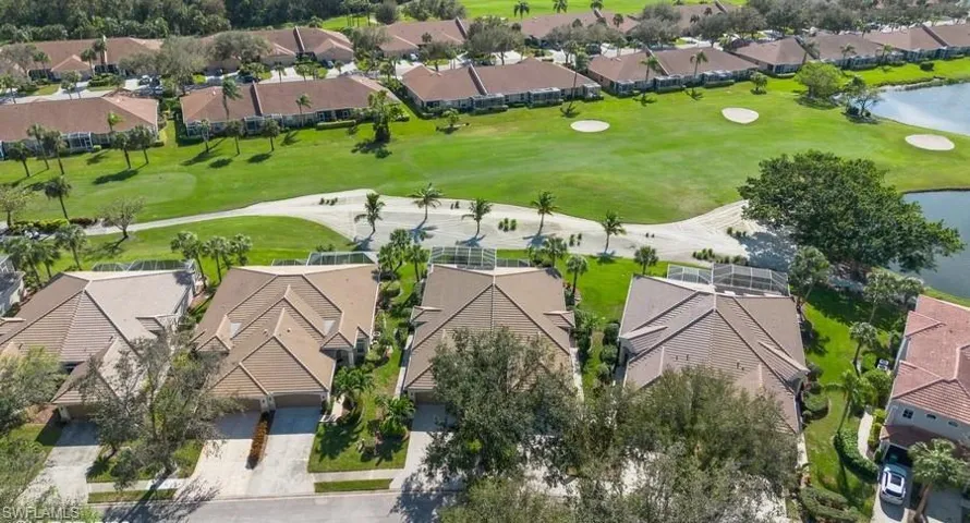 Front Birds eye view of property featuring view of landscaping, Golf Course and a partial lake view. Third building from left, on right side of building. Villas are sound and live like a single family home.