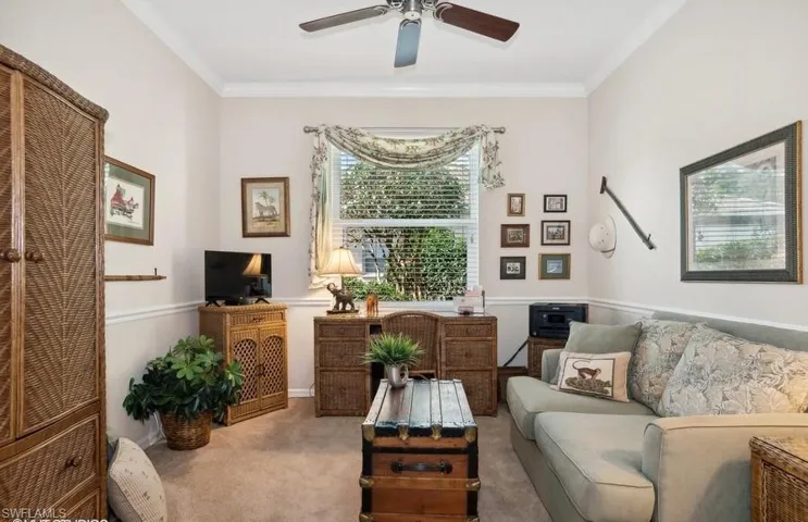 Carpeted Den featuring crown molding and ceiling fan