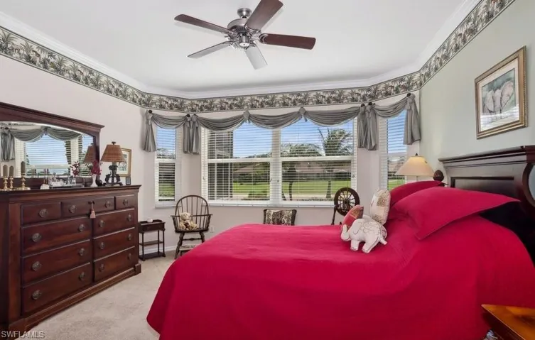 Carpeted bedroom featuring ornamental molding and ceiling fan