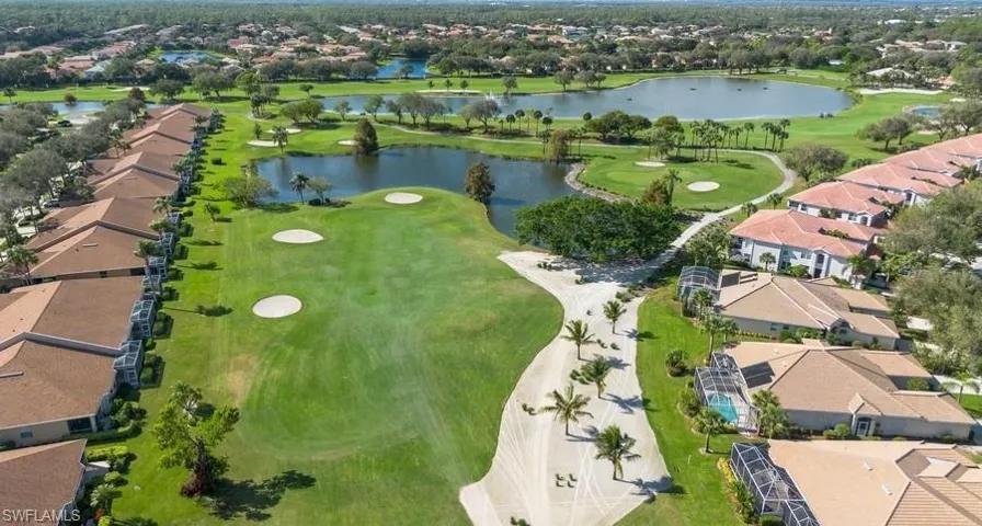 Birds eye view of property with a water view and golf course