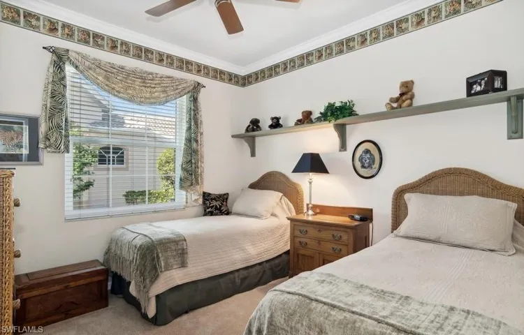 Bedroom featuring, widow allowing natural light and landscaping, ornamental molding, ceiling fan, walk in closet, and like new carpet. Door to bathroom from room for guest suite.