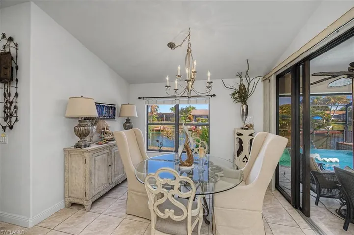 Dining space featuring lofted ceiling, hanging lights, and light tile patterned floors