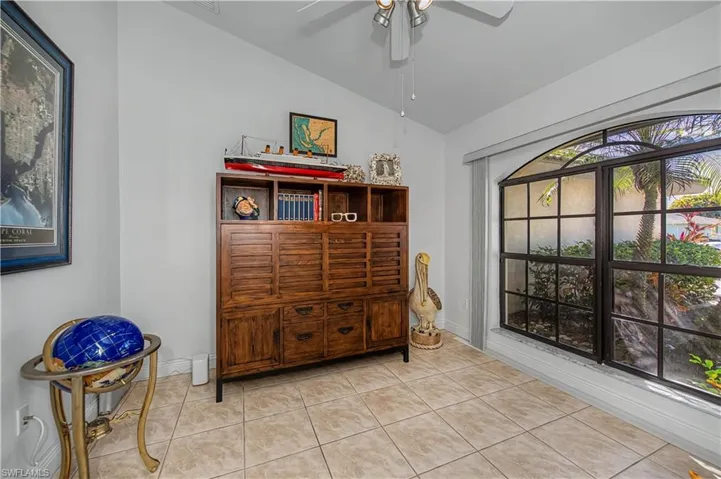 Sitting room with lofted ceiling, a ceiling fan, and tile patterned floors