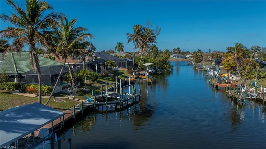 Dock area featuring boat lift, a water view, and a sunroom