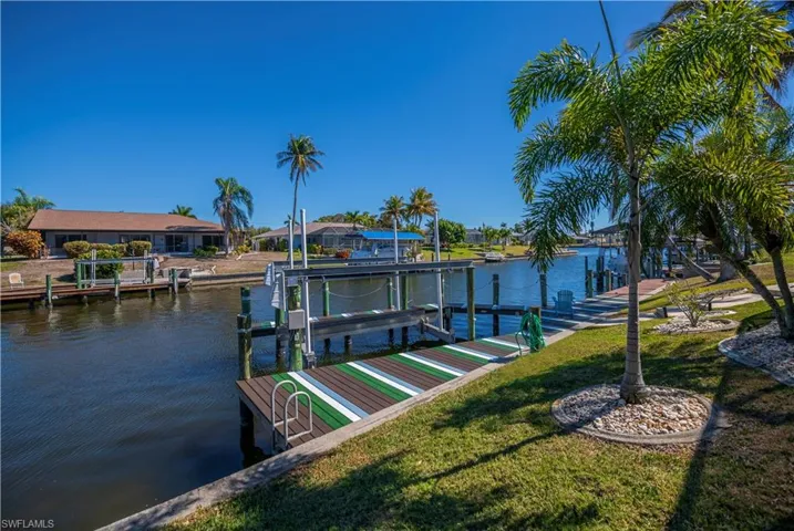 Dock with boat lift, a water view, and a residential view