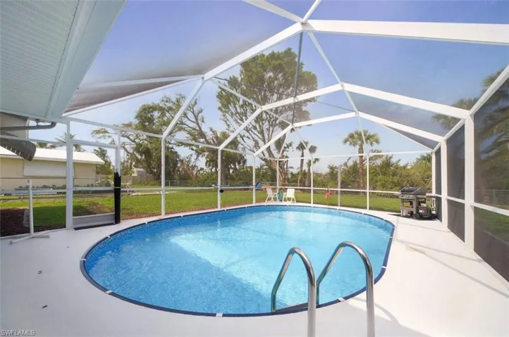 Swimming pool featuring a lanai, a patio, a sunroom, and a yard