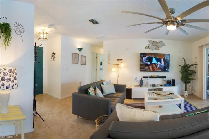 Living room featuring tile patterned floors and ceiling fan