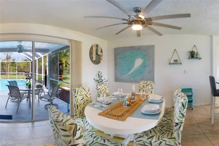 Dining area with a ceiling fan, a sunroom, and light tile patterned flooring