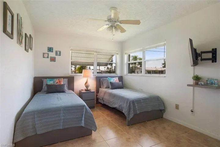 Bedroom featuring a textured ceiling, tile patterned flooring, and a ceiling fan