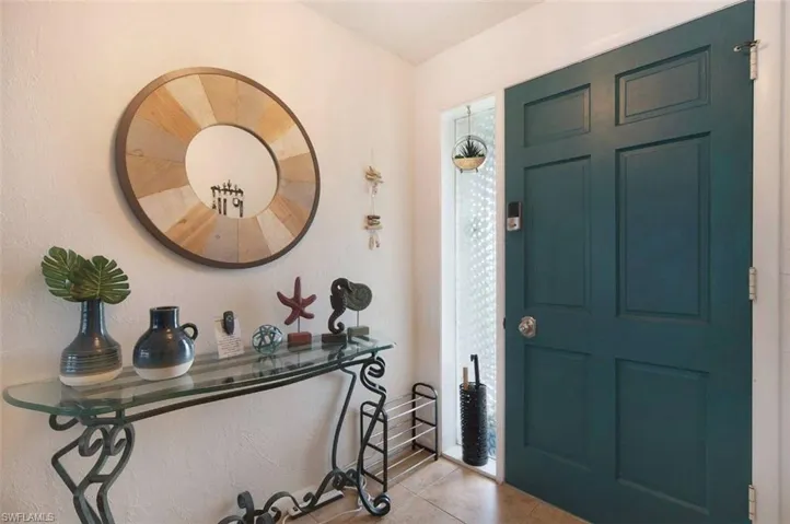 Entrance foyer featuring tile patterned floors and a textured wall