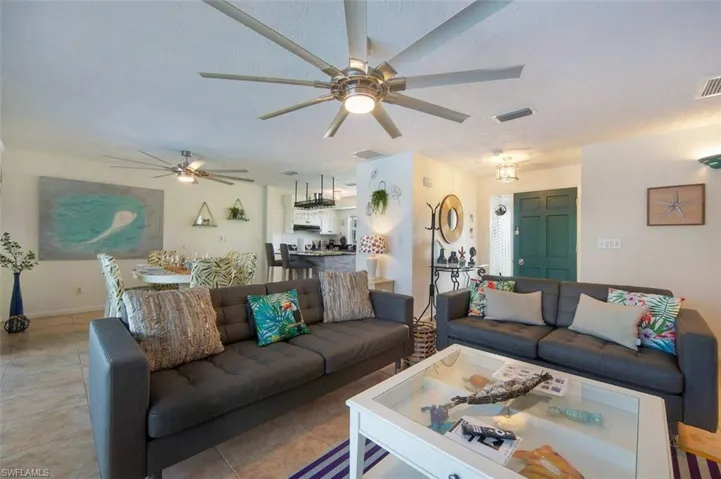 Living area featuring ceiling fan, tile patterned flooring, and a textured ceiling