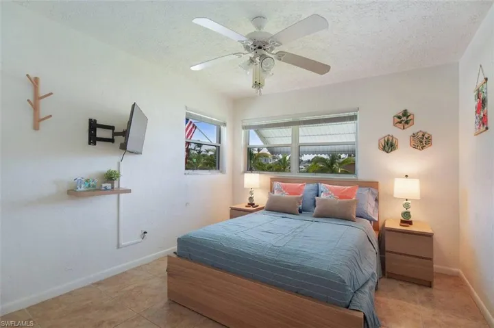 Tiled bedroom featuring a textured ceiling and a ceiling fan