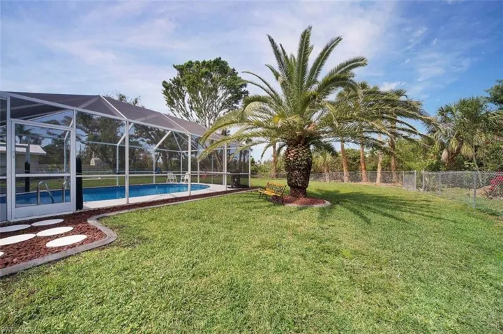 View of yard featuring a patio, glass enclosure, a sunroom, and an outdoor pool
