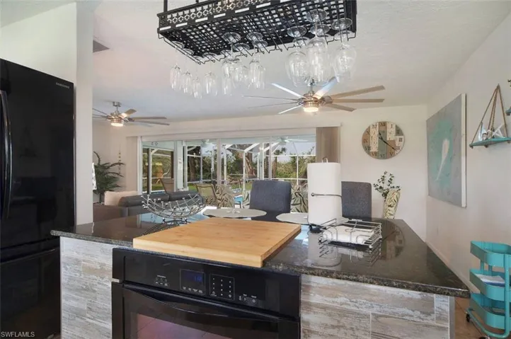 View of patio with area for grilling, ceiling fan, and outdoor dining space