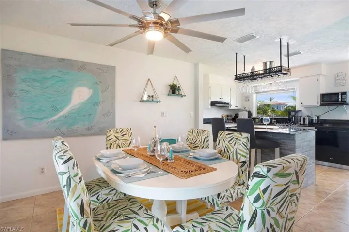 Dining space with light tile patterned floors, a textured ceiling, and ceiling fan