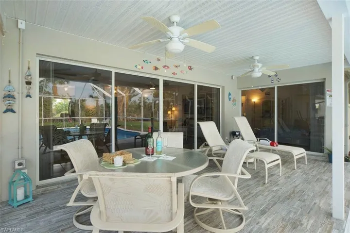 Sunroom / solarium with outdoor dining space and a ceiling fan