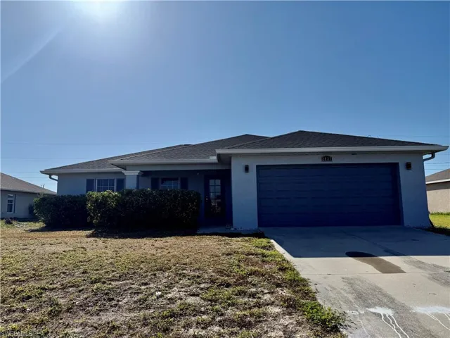 Contemporary single-story residence featuring a dark gray roof, light gray exterior siding, and a dark blue paneled garage door