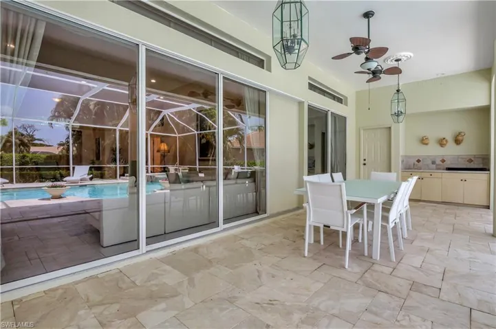 outdoor kitchen- dinning area and door to pool half-bath
