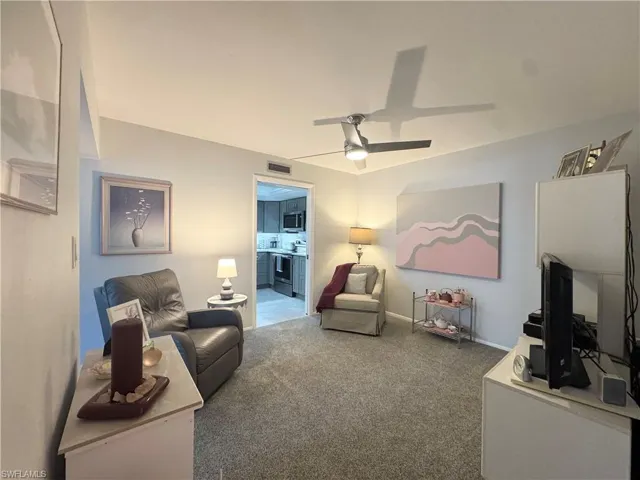 Carpeted Den featuring ceiling fan