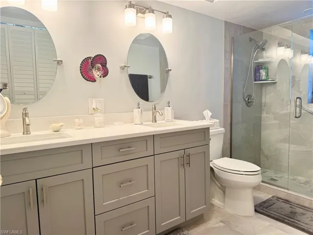 Bathroom featuring double vanity and a stall shower