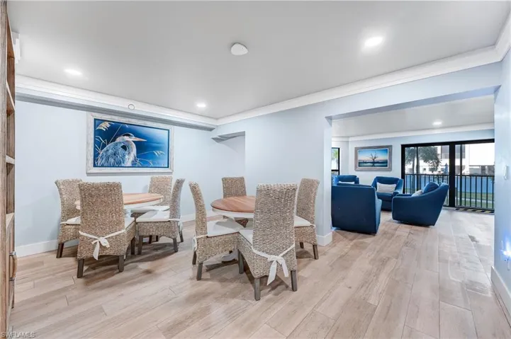 Community room with crown molding, light wood finished floors, and recessed lighting