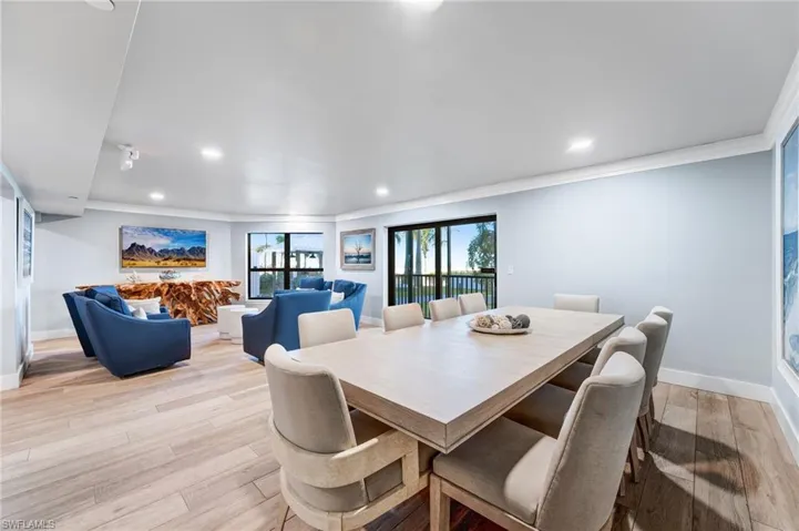 Community room featuring light wood-type flooring, crown molding, and recessed lighting.  A great place to gather.