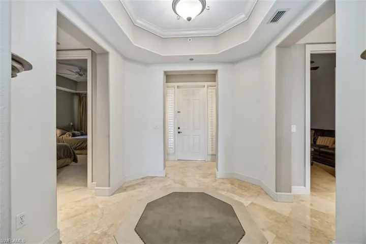 Corridor with a tray ceiling and ornamental molding