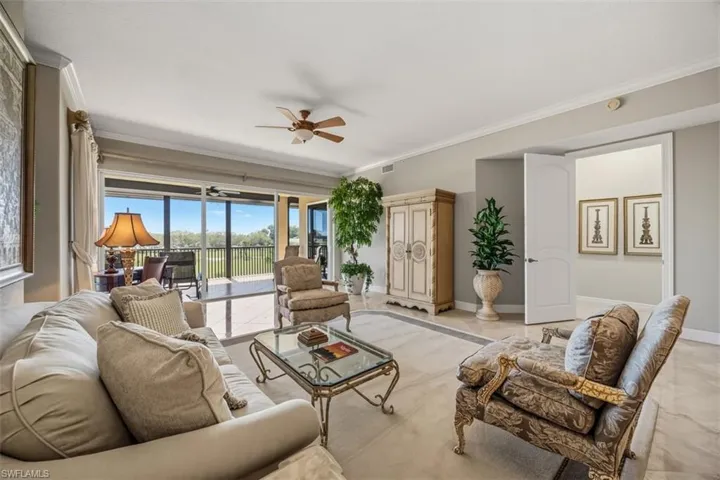 Living area with crown molding, ceiling fan, and tile patterned flooring