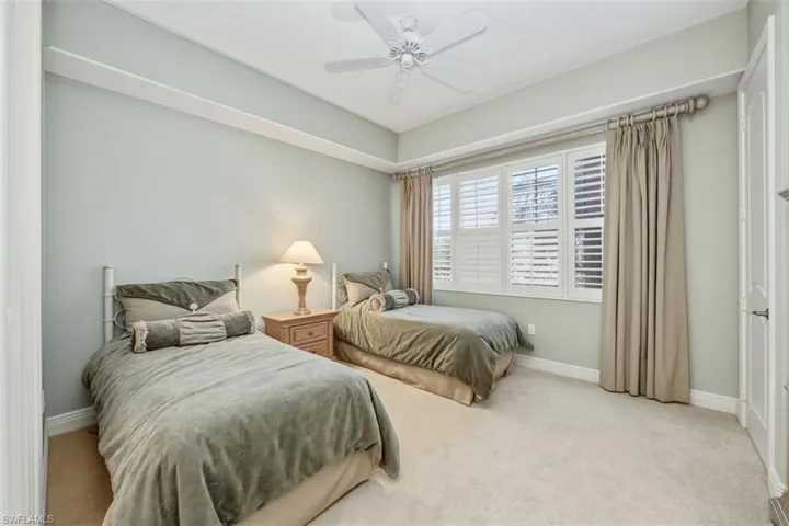 Carpeted bedroom featuring baseboards and ceiling fan