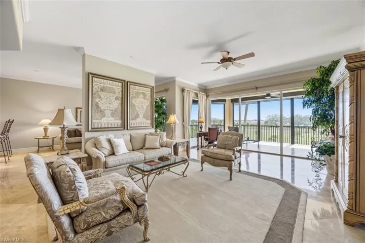 Living room featuring crown molding, a ceiling fan, and light marble finish flooring